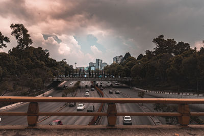 Cars on road by buildings against sky