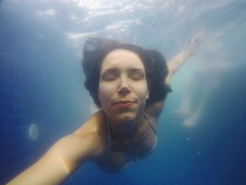 Portrait of young woman swimming in pool