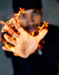 Portrait of man with fire on black background