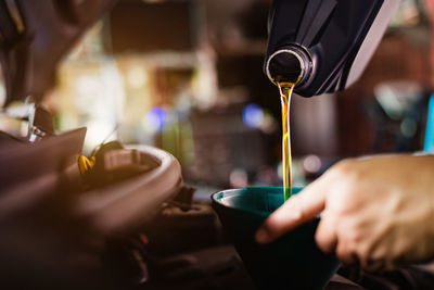 Close-up of hand pouring drink in glass