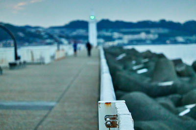 Close-up of sign by sea against sky in city