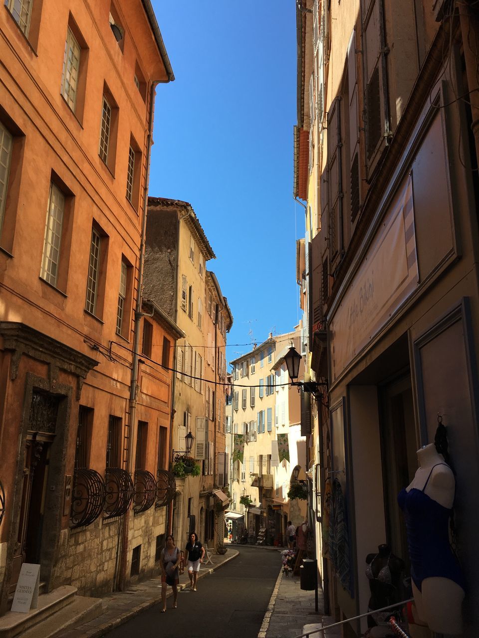 built structure, building exterior, architecture, city, street, residential building, shadow, city life, sunlight, clear sky, blue, sunny, the way forward, day, sky, outdoors, building story, old town, person, residential district