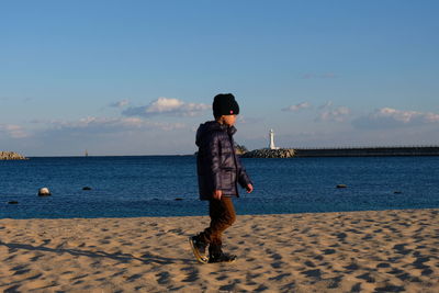 Full length of boy walking on sand at beach