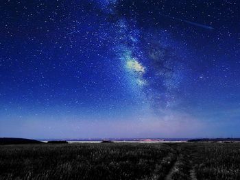 Scenic view of landscape against star field at night