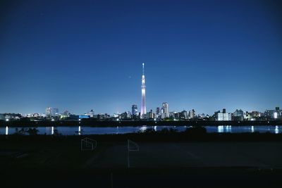 Illuminated cityscape against sky at night