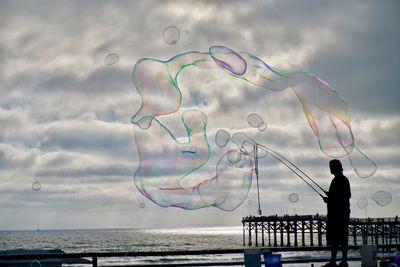 Scenic view of rainbow over sea against sky