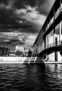Bridge over river against sky in city