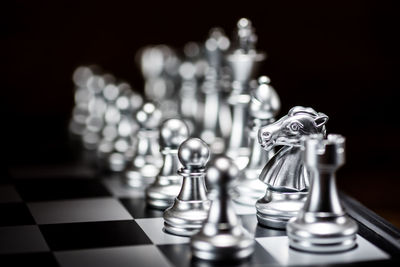 Illuminated chess pieces against black background