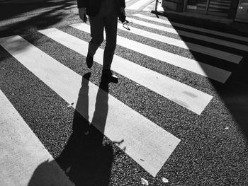 Low section of man walking on zebra crossing