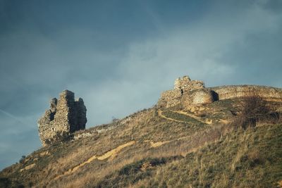 Low angle view of fort on rock against sky