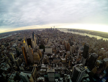 High angle view of city buildings against cloudy sky