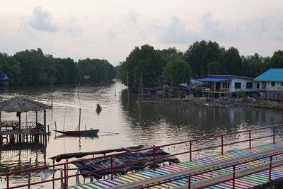 Scenic view of river by buildings against sky