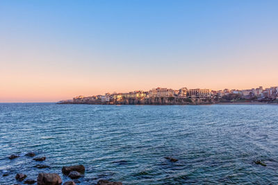 Scenic view of sea against clear sky at sunset