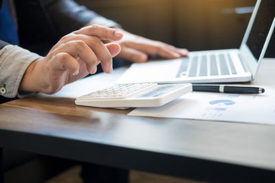 Close-up of person using laptop on table