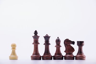 Low angle view of chess pieces against white background