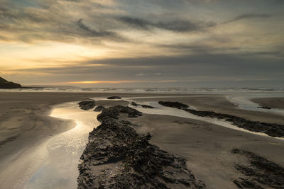 Scenic view of beach against sky during sunset