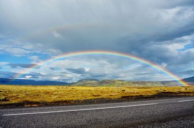 Scenic view of rainbow over landscape against sky