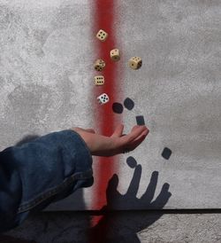 Close-up of person throwing dices against wall