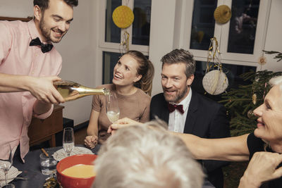 Cheerful group of friends opening champagne on new year's eve