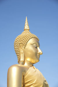 Low angle view of statue against temple against clear sky