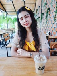 Portrait of young woman sitting on table