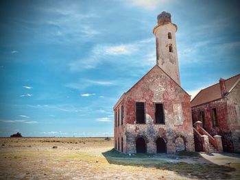 Old historic building on field against sky