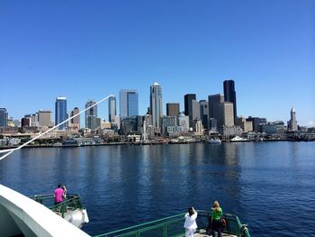 City at waterfront against blue sky