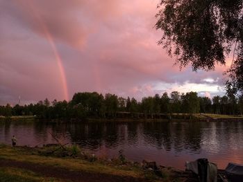 Scenic view of rainbow over lake against sky