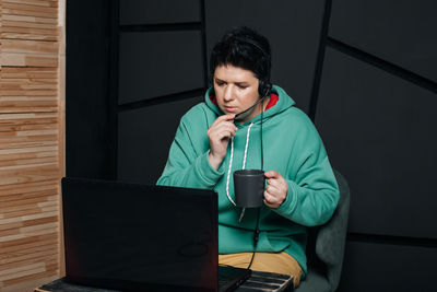 Young man using mobile phone while sitting at home