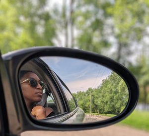 Reflection of woman on side-view mirror