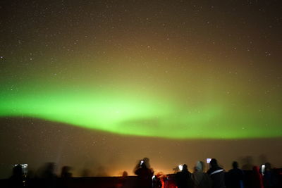 Low angle view of people against sky at night