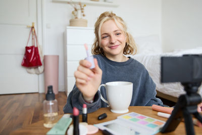 Young woman using mobile phone at home