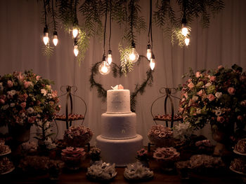 Flowers in vase by cake on table