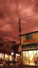 Illuminated city against sky at sunset