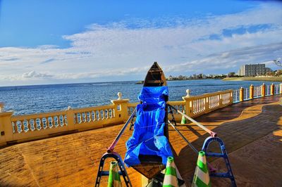 Full length of railing by sea against sky