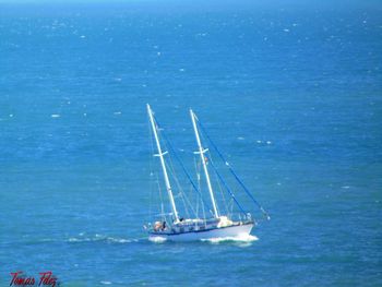 Boat sailing in sea against blue sky