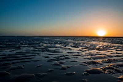 Scenic view of sea against clear sky during sunset