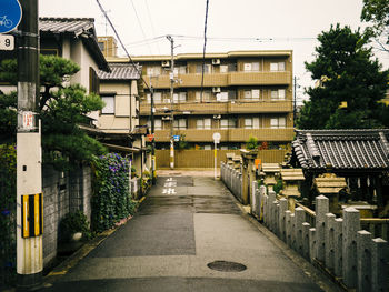 Street amidst buildings in city against clear sky