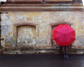 Woman with umbrella standing on street during rainy season