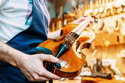 Midsection of man playing guitar