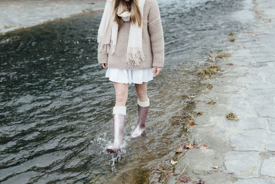 Low section of woman walking in water