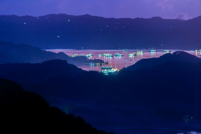 Scenic view of illuminated mountains against sky at night