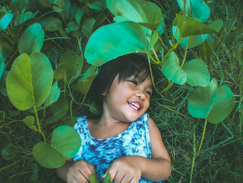 Portrait of a smiling girl with green leaves