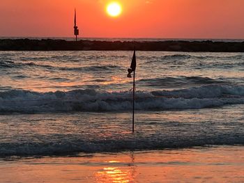 Scenic view of sea against orange sky