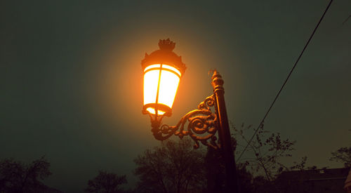 Low angle view of illuminated street light against sky
