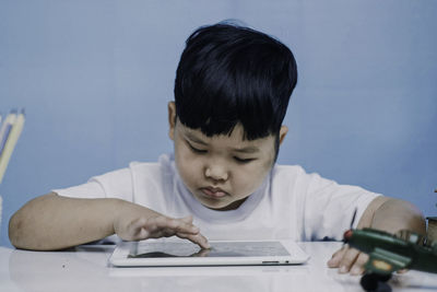 Portrait of boy using mobile phone on table