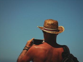 Close-up of man wearing hat on beach against sky