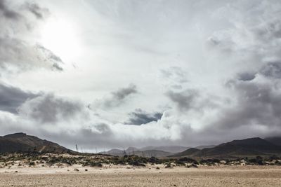 Scenic view of mountains against cloudy sky