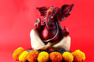 Close-up of buddha statue against red background