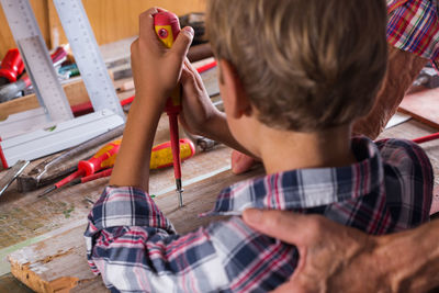 High angle view of boy sitting at home